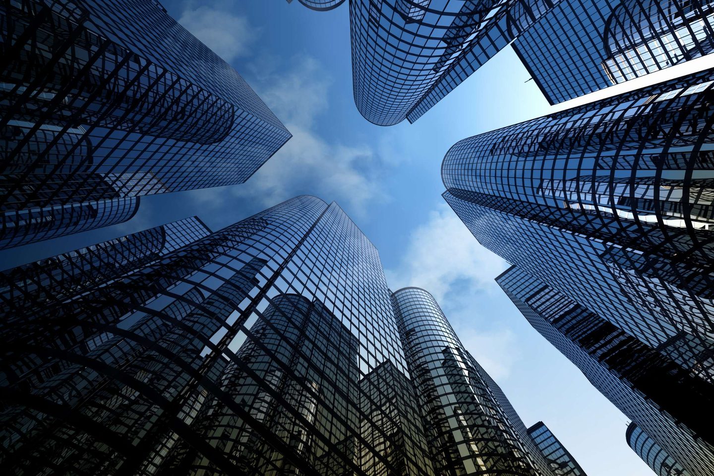 Glass office towers rising into a blue sky